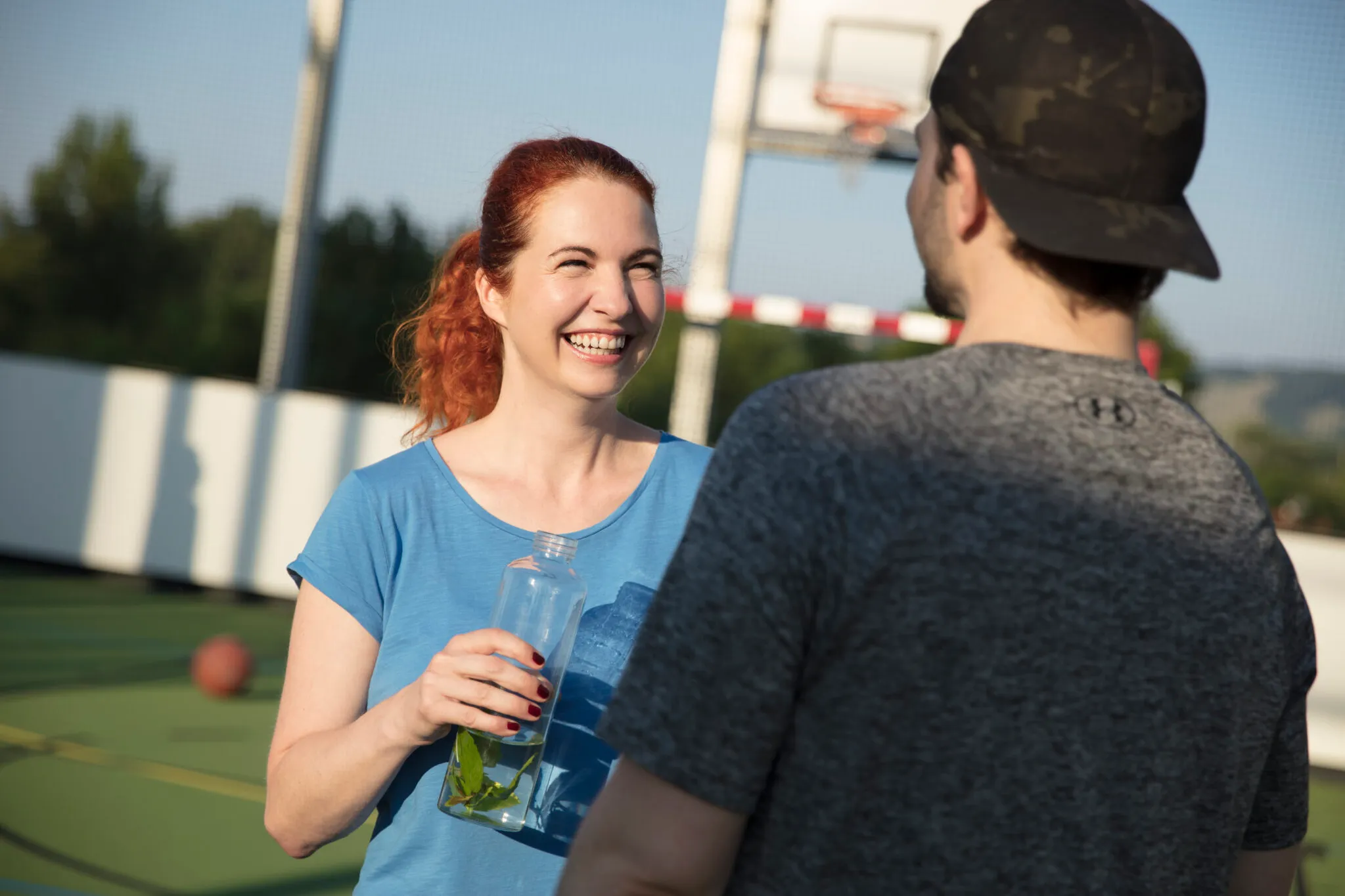 Ein Mann und eine Frau unterhalten sich auf dem Sportplatz