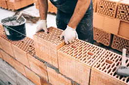 Nahaufnahme eines Bauarbeiters, der eine Mauer ziegelt