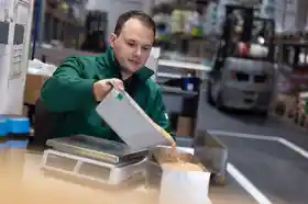 Ein Mann schüttet Saatgut in eine kleine Kiste.