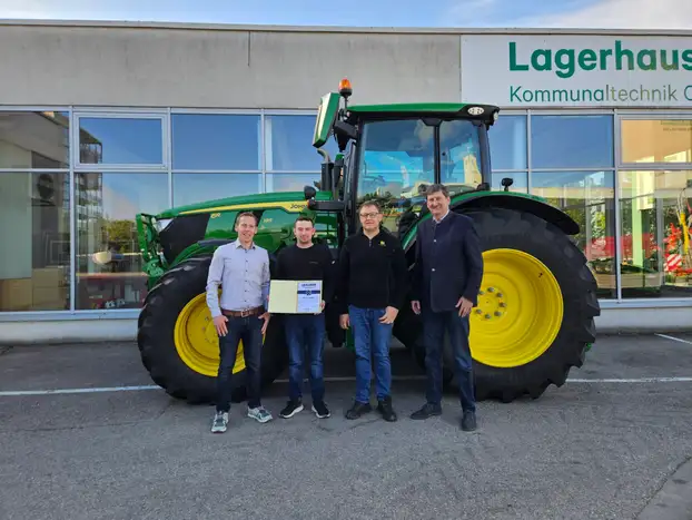 Niklas mit seinen Kollegen vor einem John Deere Traktor